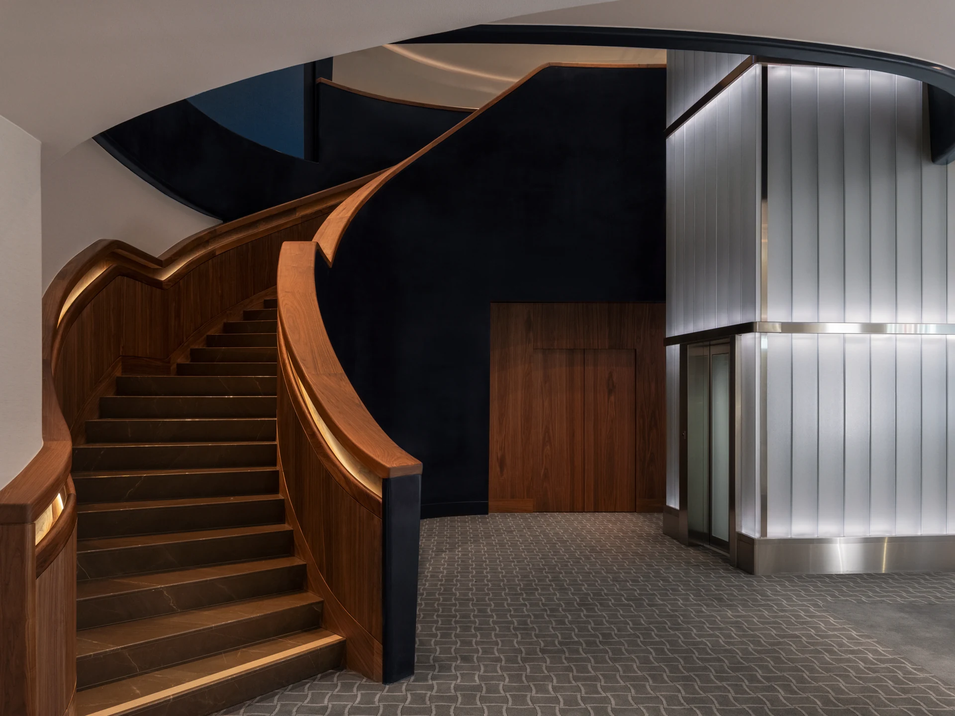 Curved wooden staircase and cylindrical lift connecting the two floors at Nymans Ur